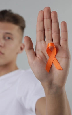 Hand met oranje ribbon, symbool voor Multiple Sclerose